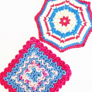 May include: Two crocheted pot holders in pink, blue, and white. One is a square with a ruffled edge and the other is a hexagon with a starburst design.
