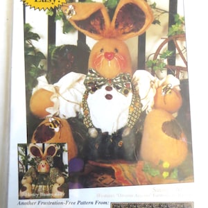 May include: A craft pattern for a stuffed bunny and bee. The pattern is titled "Sunny Bunny & Bumble Bee Friends #450" and includes the text "Quick & Easy!" The pattern is from Happy Hollow Designs and includes the text "Another Frustration-Free Pattern From:" and a list of features.