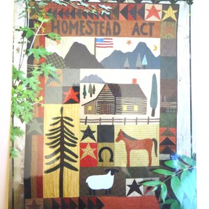 May include: A colorful patchwork quilt with a rustic farmhouse theme. The quilt features a log cabin, a horse, a sheep, a pine tree, a horseshoe, stars, and the words "Homestead Act".
