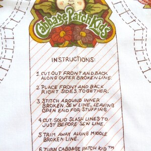 Puede incluir: Un patr&oacute;n de costura de Cabbage Patch Kid con instrucciones sobre c&oacute;mo coser la mu&ntilde;eca. El patr&oacute;n presenta una ilustraci&oacute;n colorida de un Cabbage Patch Kid con una cabeza verde frondosa y una flor roja y marr&oacute;n.