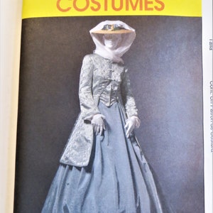 May include: A vintage McCall's Costumes sewing pattern featuring a woman wearing a long, blue skirt and a silver jacket with a white lace collar. The pattern is for a costume from the Victorian era.