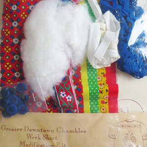 May include: A craft kit for making a work shirt. The kit includes fabric, buttons, trim, and instructions. The kit is labelled "Greater Downtown Chamblee Werk Shirt Modification Kit" and "The Pennsylvania Dutch Treat".