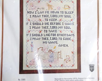 May include: A cross-stitch sampler pattern for a child's prayer. The pattern features a child in bed with a teddy bear and a moon. The text reads "Now I lay me down to sleep, I pray thee, Lord, my soul to keep. If I should die before I wake, I pray thee, Lord, my soul to take. If I should live for other days, I pray thee, Lord, to guide my ways. Amen."