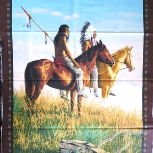 Puede incluir: Panel de tela con una pintura de dos figuras nativas americanas a caballo en un campo de hierba. Una figura sostiene una lanza. Los caballos son marrones y tostados, y el cielo es azul. El panel tiene un borde marrón con un patrón decorativo.
