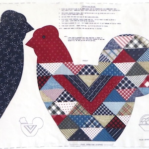 Op de afbeelding: Een stoffen paneel met haan- en mandvormen om te quilten. De haan is gemaakt van patchwork driehoeken in rood, blauw en beige. De andere haan is effen marineblauw. Een mand met eieren is ook inbegrepen.