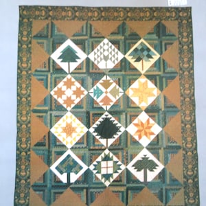 May include: A quilt pattern featuring a sampler of different quilt blocks, including trees, stars, and geometric shapes. The quilt is made in shades of green, brown, and yellow. The title of the pattern is "Starry Pines Sampler Quilt for Prairie Star Quilts by Julie Larsen".