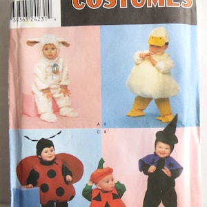 Peut inclure: Patron de couture Simplicity Costumes 9318 présentant des illustrations de nourrissons dans diverses tenues : un agneau blanc, un canard blanc, une coccinelle rouge, une citrouille orange et un costume de sorcier noir avec chapeau pointu.
