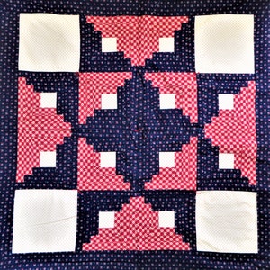 Puede incluir: Una colcha con un patrón repetitivo de cuadrados rojos y blancos sobre un fondo azul oscuro. Los cuadrados están dispuestos en un patrón geométrico, creando un diseño visualmente atractivo.