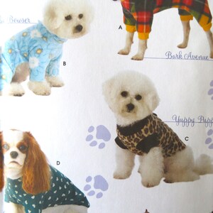 May include: Four different dog clothing designs for small dogs. The designs include a blue and white patterned pajama, a red and black plaid pajama, a leopard print sweater, and a teal and white heart patterned sweater. The text "Woof Wear by Wendy" is visible in the bottom right corner of the image.