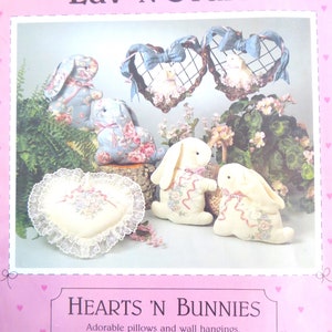 May include: A craft pattern for making heart-shaped cushions and wall hangings with bunny designs. The pattern includes instructions for tracing and painting the designs. The text on the pattern reads "Luv 'N Stuff" and "Hearts 'N Bunnies".