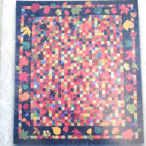 May include: A quilt pattern titled "Autumn in Nebraska" with a colorful patchwork design featuring a variety of fall leaves in a border around the quilt. The Bee Creek Quilting Company presents this bed quilt pattern.