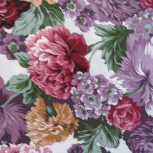 Puede incluir: Una tela floral con fondo blanco y una variedad de flores en tonos rosa, morado y marrón. Las flores están dispuestas en un patrón aleatorio y están rodeadas de hojas verdes.