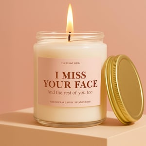 May include: A lit, hand-poured soy wax candle in a clear glass jar with a gold lid. The label reads "I MISS YOUR FACE" and "And the rest of you too". The candle is from The Peony Wick.