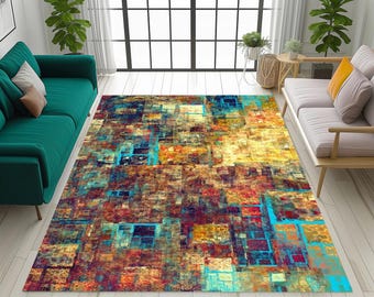 May include: A rectangular area rug with an abstract design. The rug features a mosaic of colors including blue, yellow, red, and brown. The rug is placed on a light-colored wooden floor, with furniture visible in the background.