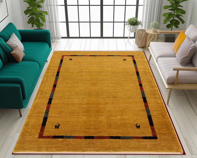 May include: Mustard yellow area rug with a rectangular design. The rug has a dark red border and a patterned border with black, red, and green stripes. Small animal figures are in each corner. The rug is placed in a living room setting.