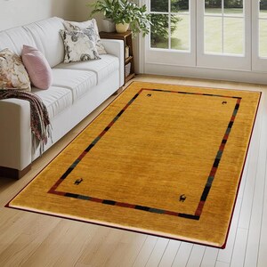 May include: Mustard yellow rectangular area rug with a dark red border. The rug has a striped design in the border with black, green, and red stripes. Small animal silhouettes are in each corner. The rug is placed on a hardwood floor.