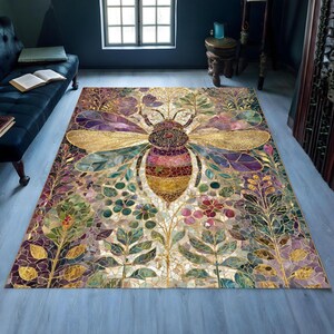 May include: A rectangular rug with a large bee motif. The bee has gold wings and a striped body. The rug features a mosaic-style pattern with floral and leaf designs in purple, green, and gold colours.