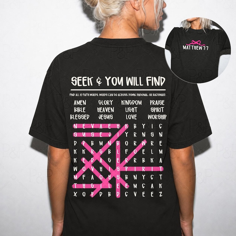 May include: A black t-shirt featuring a white word search puzzle on the back with the text SEEK AND YOU WILL FIND and a list of faith words. Pink lines highlight words within the grid. A small circular inset shows the front with MATTHEW 7:7 text.