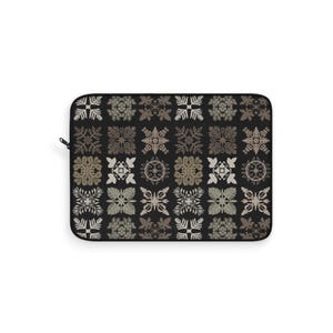 May include: Black laptop sleeve featuring a repeating pattern of stylized floral and geometric designs in shades of beige, gray, and white. The sleeve has a zipper closure on the left side.