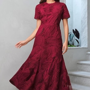 Mini abito da donna bordeaux con stampa floreale, orlo a balze, scollo rotondo, maniche corte e inserti patchwork.