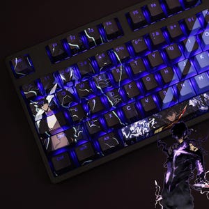 May include: A black mechanical keyboard featuring custom keycaps with anime-style character illustrations and glowing purple backlighting. The keys display white letters and symbols, with specific keys showcasing detailed artwork of a dark-haired figure.