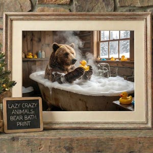 May include: Framed print featuring a brown bear relaxing in a clawfoot bathtub filled with bubbles, holding a yellow rubber duck. The image includes a small Christmas tree, a fireplace, and a sign that reads "Lazy Crazy Animals: Bear Bath Print."