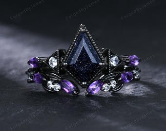 May include: A black ring with a large, dark blue, diamond-shaped center stone. The ring is accented with smaller purple and white stones. The band has an intricate design. The words "ForgedbyJames" are printed on the image.