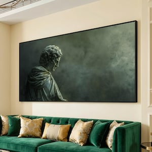 May include: Large framed artwork featuring a classical bust sculpture in shades of gray and green. The artwork is mounted above a green velvet sofa with decorative pillows. The overall aesthetic is elegant and sophisticated, suitable for home decor.