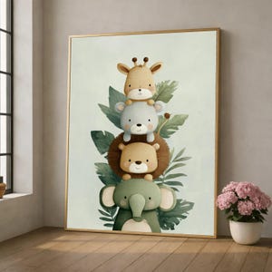 May include: A framed watercolour print depicting a stack of cartoon animals: a giraffe, a bear, a lion, and an elephant. The animals are surrounded by green leaves, with a light green background and a gold frame. The artwork is displayed on a wooden floor.