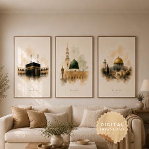 Może przedstawiać: Zestaw trzech pionowych grafik ściennych z akwarelowymi ilustracjami Mekki, Medyny i Al-Quds. Każdy wydruk przedstawia zabytki architektury w delikatnych odcieniach beżu, brązu i zieleni z etykietami tekstowymi identyfikującymi każdą lokalizację.