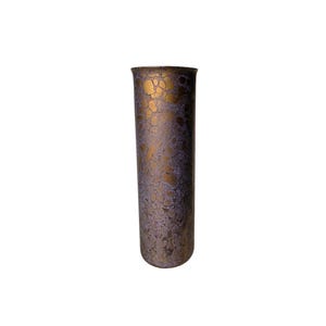 May include: A tall, cylindrical vase with a textured surface. The vase features a pattern of gold and purple tones. The top rim is slightly flared. The vase is a decorative item.