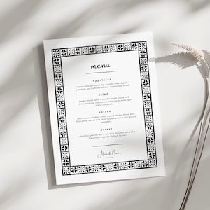 May include: A white menu card with a black decorative border and text. The menu includes appetizer, salad, entrée, and dessert options. The menu is titled "menu" and signed "Alice & Noah".