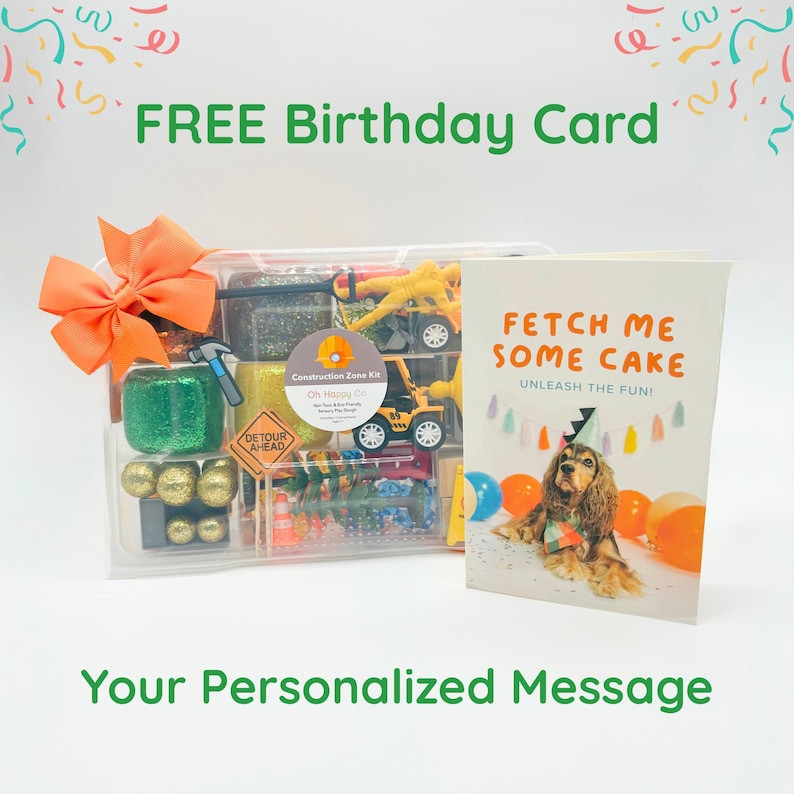 May include: A clear plastic container with a construction-themed kit, an orange bow, and a birthday card that says "Fetch Me Some Cake". The kit includes toy trucks, glitter, and a detour sign. The card features a dog.