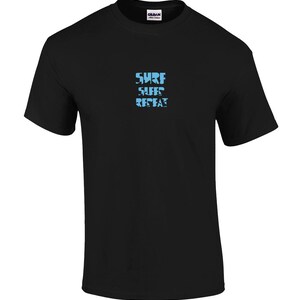 May include: A black short-sleeve t-shirt with a crew neckline. Centered on the chest is the text "SURF SURF REPEAT" printed in a light blue, distressed, block-style font. The shirt features a Gildan brand label at the inner neck area.