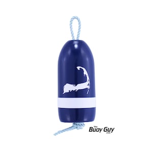 May include: A blue and white nautical buoy ornament with a white outline of Cape Cod on the front. The buoy has a white stripe and a light blue rope.