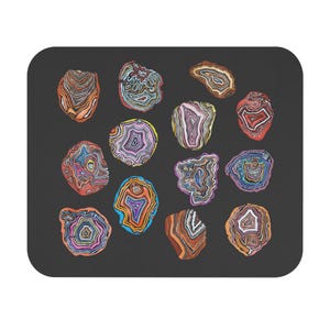 May include: A black rectangular mousepad featuring a pattern of colorful agate slices. The agate slices have concentric bands of orange, blue, pink, and purple. The mousepad is a useful desk accessory.