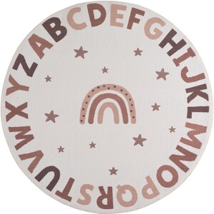 May include: Round, off-white rug featuring the alphabet in various shades of brown around the perimeter. A brown rainbow and stars are in the center. The rug is designed for a nursery or playroom.