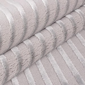 May include: Close-up of a rolled-up, light gray fabric with vertical, textured stripes in a lighter shade of gray. The fabric appears soft and plush, with a subtle sheen. The stripes create a sense of depth and dimension.