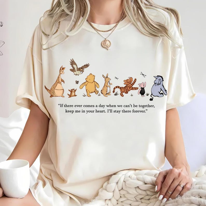 以下が含まれることがあります： クリーム色のTシャツ。カンガルー、クマ、ウサギ、トラなど、漫画のキャラクターのイラストが描かれています。シャツには「もし私たちが一緒にいられなくなる日が来ても、私のことを心に留めておいてください。私は永遠にそこにいます。」という引用があります。