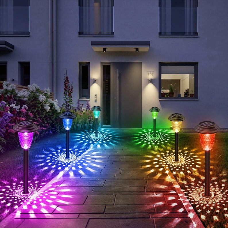 Set of 10 RGB color-changing solar garden stake lights installed along a lawn pathway