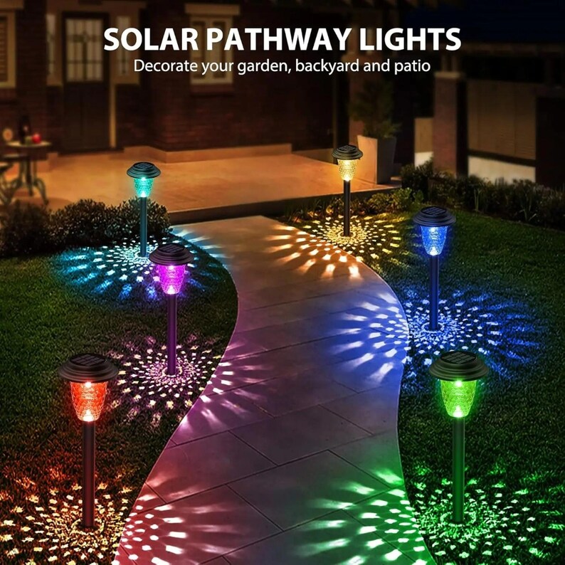 Solar pathway lights displaying multicolor RGB illumination along a winding garden path at night