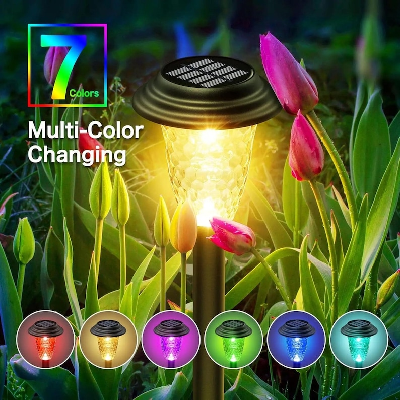 Solar stake light in warm white mode glowing among tulip flowers, showing 7 available color options