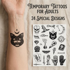 Könnte beinhalten: Schwarzes temporäres Tattoo einer Katze mit Mond und Stern auf einem Arm. Ein Bogen mit 24 speziellen temporären Tattoo-Designs enthält einen Totenkopf, einen Hexenhut, einen Schlüssel, einen Mond und andere mystische Illustrationen. Text: "TEMPORARY TATTOOS FOR ADULTS".