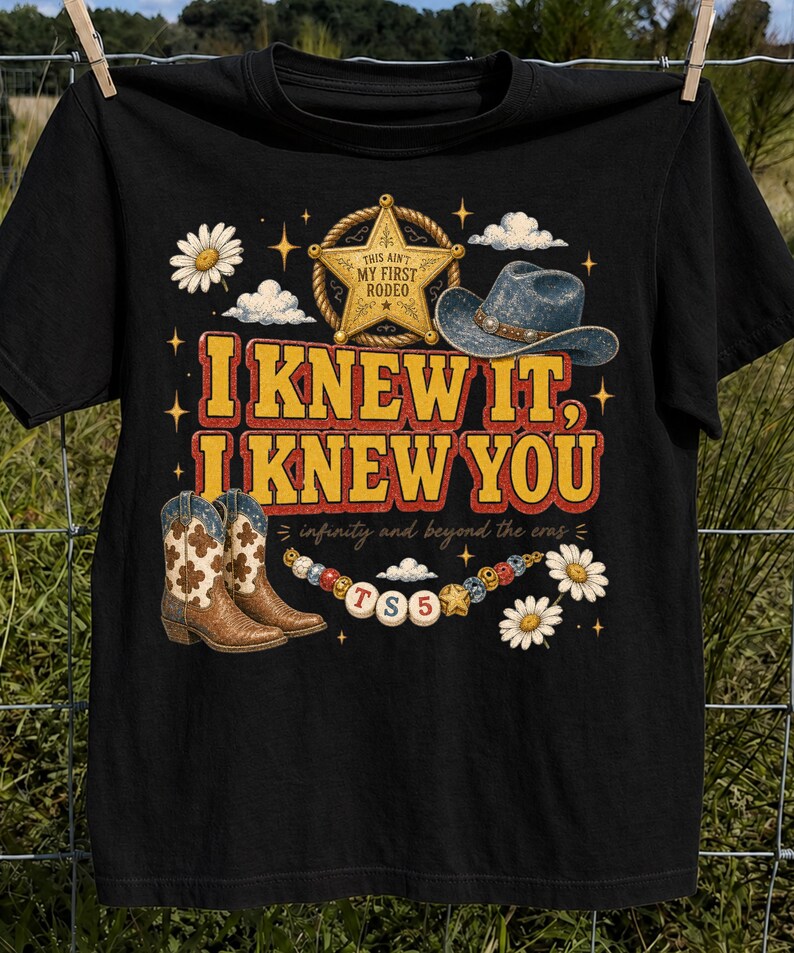 以下が含まれることがあります： 「I KNEW IT, I KNEW YOU」、「THIS AIN'T MY FIRST RODEO」、「infinity and beyond the eras」というテキストがプリントされた黒いTシャツ。保安官のバッジ、カウボーイハット、カウボーイブーツ、デイジーの花、ビーズが描かれたグラフィックデザインが特徴です。