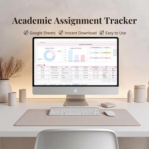 May include: A computer screen displaying an "Academic Assignment Tracker" spreadsheet, with charts and tables. A keyboard, mouse, and desk mat are in front of the monitor. The text "Google Sheets", "Instant Download", and "Easy to Use" are also visible. The setup is on a white desk.