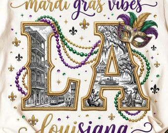 May include: White t-shirt with a gold and purple "Mardi Gras Vibes LA Louisiana" design. The design includes a mask, beads, and illustrations of buildings and a riverboat. The shirt has a crew neck and short sleeves.