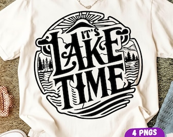 May include: A cream-colored short-sleeve t-shirt featuring a large black circular graphic on the front. The design includes a stylized sun, clouds, pine trees, and water, with the bold text "IT'S LAKE TIME" centered within the circular frame.