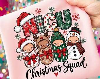May include: A light pink t-shirt featuring a graphic with the text NICU Christmas Squad. The design includes four swaddled infants dressed as a Santa, a reindeer, a Christmas tree, and a snowman, surrounded by red and green snowflakes.