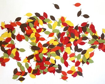 May include: A large pile of fall leaves in various shades of red, orange, yellow, and brown. The leaves are scattered on a white background.