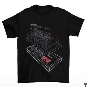 May include: Black t-shirt featuring a white schematic of a classic video game controller. The controller design includes red buttons and the Nintendo logo. The graphic is a detailed, exploded view of the controller's internal components.